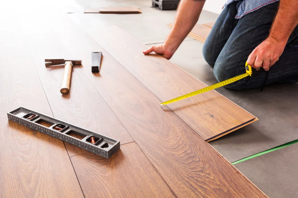 Hands-of-a-carpenter-fitting-engineered-wood-floor-panels-together